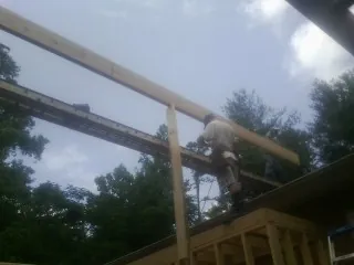 Carpenter setting a ridge beam over a new addition frame — Ice Dam Removal by Roofing Brothers in Dorchester Center
