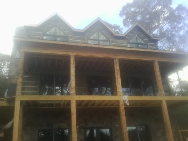 Dormers and porch framing on a large log home under construction — Roof Coating work by our crew in Dorchester Center