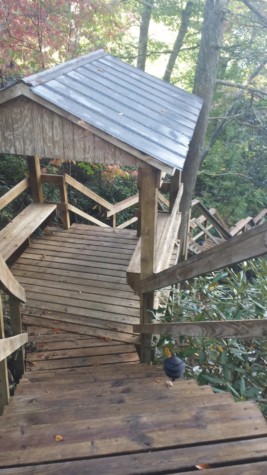Metal roofed shelter over wooden steps on a wooded walkway — Skylight Repair & Installation work by our crew in Dorchester Center
