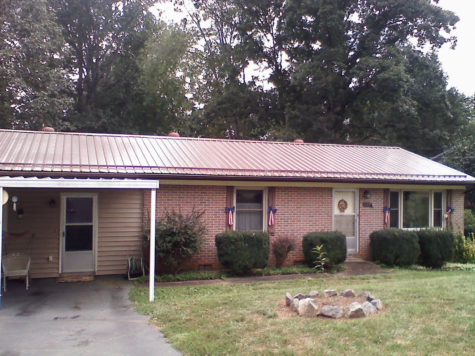 Bronze metal roof and carport on a brick ranch home — Roof Repair work by our crew in Dorchester Center